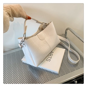 Détail de la texture crocodile blanche et de la poignée sur ce sac cabas de luxe