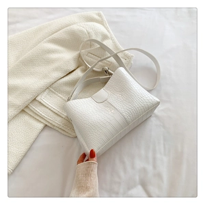 Gros plan sur la texture crocodile blanc et les détails du sac à main en similicuir