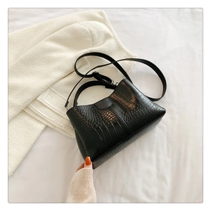 Gros plan sur la texture crocodile noire d'un sac à main élégant avec détail de bandoulière