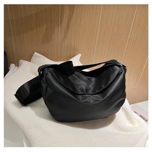 Detail of black nylon crescent bag showing waterproof fabric and adjustable shoulder strap
