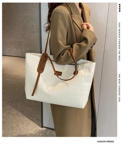 Detailed view of a white woven texture tote bag worn by a model for daily commute