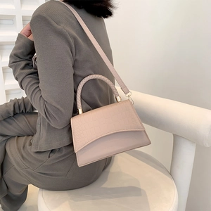 Beige faux crocodile skin handbag with woven handle and adjustable shoulder strap
