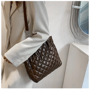 Detail der kaffeebraunen Stepp-Tote-Bag mit silbernen Metallringen und dünnen Riemen
