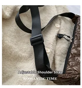Detail view of the adjustable black nylon shoulder strap on a quilted brown crossbody bag