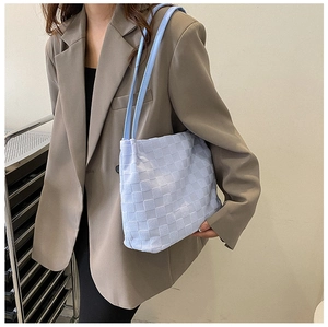 Détail du sac à bandoulière bleu clair avec texture tissée et fine bandoulière minimaliste
