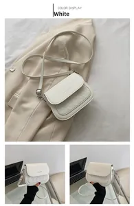 Close-up of white saddle bag with diamond stitching and adjustable strap details