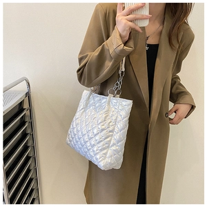 Detail der weißen Stepp-Tasche mit silberner Kette und poliertem Kunstleder-Finish