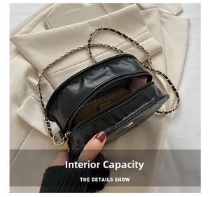 Detailed view of internal capacity of black quilted chain bag with leather strap