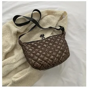 Detailed size comparison of dark brown quilted crossbody bag next to a smartphone