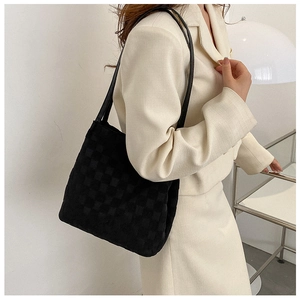 Vue latérale détaillée d'un sac cabas à damier noir porté par un mannequin dans un style minimaliste