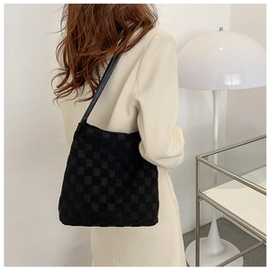 Détail du sac cabas noir à motif damier texturé avec bandoulière fine et fini mat