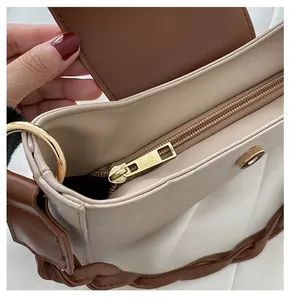 Close-up of smooth metal zipper and magnetic closure on the beige crossbody bag