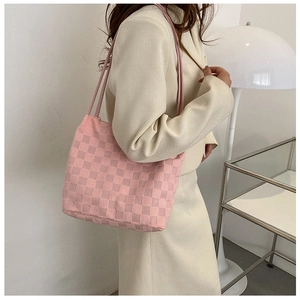 Texture détaillée du sac cabas en tricot à carreaux roses avec motif en relief et sangle