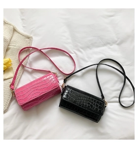 Detailed overhead view of black and pink crocodile embossed leather baguette shoulder bags