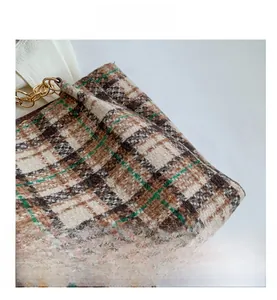 Gros plan sur un sac à bandoulière en tweed à carreaux avec chaînes dorées chic
