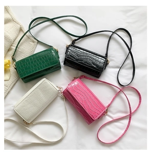 Detailed view of four colorful faux crocodile skin baguette bags in glossy leather finish