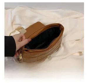 Internal view showing brown quilted bag capacity with gold hardware and metal zipper
