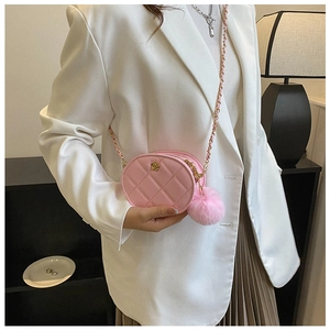 Close-up of pink oval crossbody bag with quilted texture and gold floral buckle