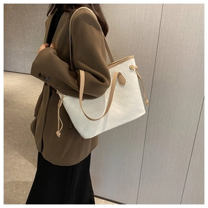 Detailed side view of white woven tote bag with khaki straps on a fashion model