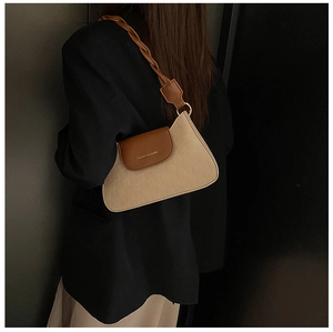 Close-up of beige contrast shoulder bag with brown leather flap and woven strap detail