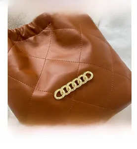 Detail shot of brown quilted leather tote with elegant gold chain and diamond stitching