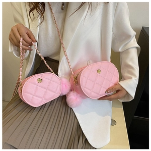 Detail of pink quilted oval crossbody bag with gold flower clasp and chain strap