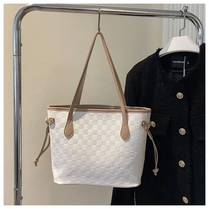 Detail of white checkered tote bag featuring brown slim handles and side drawstring accents