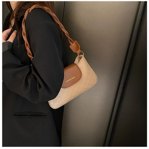 Detail of light khaki underarm bag featuring textured grid pattern and woven strap