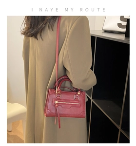 Mini borsa Boston rossa retrò con cerniera in metallo e nappe su blazer marrone