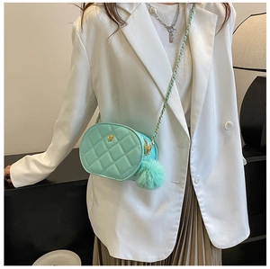 Detail of mint green quilted oval crossbody bag with gold floral hardware and chain strap