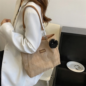 Minimalist light brown quilted tote bag with chain strap and fuzzy ball decoration