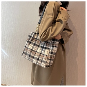 Détail d'un sac cabas en tweed tricolore avec lanières en cuir noir et chaîne dorée