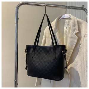 Close-up of black checkered tote bag with Damier pattern and side drawstring detail