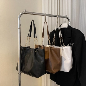 Trois sacs cabas texturés en noir, marron et blanc avec bandoulières à chaîne métallique
