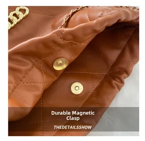 Close-up of brown quilted bag showing high-quality magnetic buckle and gold chain strap