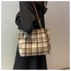 Sac cabas à carreaux rétro avec bandoulière en cuir marron et chaîne dorée sur le mannequin
