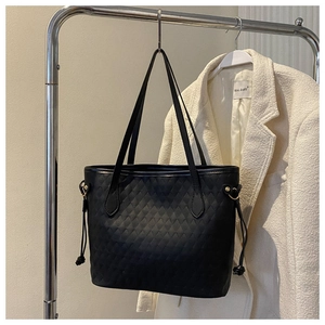 Close-up of black quilted leather tote bag with side drawstring details and luxury texture