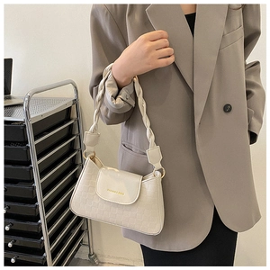 Detailed close-up of cream white quilted handbag with braided shoulder strap and gold hardware