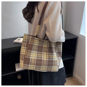 Détail du sac cabas en tweed à carreaux marron avec bandoulière et chaîne dorée