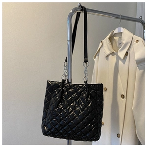 Nahaufnahme der großen schwarzen Stepptasche mit glänzendem Finish und Kettenriemen