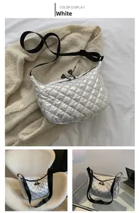 Close-up of silver quilted crossbody bag with adjustable black strap and twin zippers