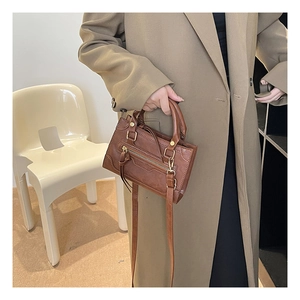 Dettaglio borsa a tracolla marrone vintage con cerniere in metallo e manici