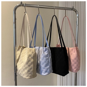 Détail de quatre sacs fourre-tout en tricot à carreaux gaufrés en crème, bleu, noir et rose