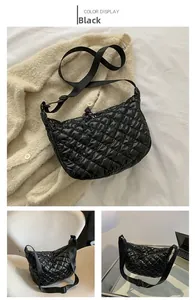 Detail of black quilted puffer tote bag with adjustable shoulder strap and zip closure