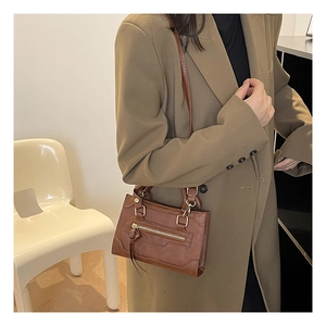 Dettaglio borsa a mano vintage marrone con cerniera a frange e tracolla regolabile