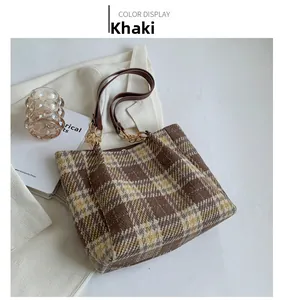 Gros plan du sac cabas en tweed à carreaux kaki avec bandoulière et chaîne dorée