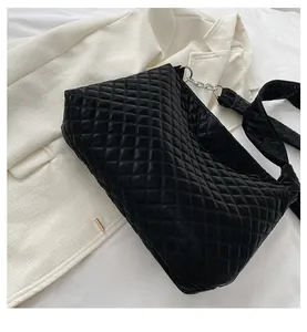Detail shot of black quilted shoulder bag featuring silver chain and premium nylon texture