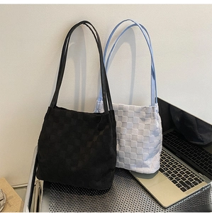 Vue détaillée de grands sacs cabas avec motif à damier texturé en noir et bleu clair