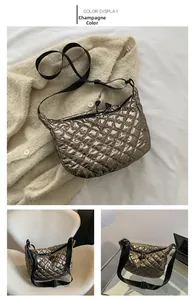 Detail view of champagne metallic quilted crossbody bag with adjustable black strap