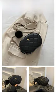 Detail view of large black quilted oval bag with gold flower clasp and chain strap